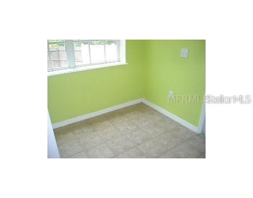 A small room with light green walls, a window, and tan tile flooring — 4204 PLANTATION COVE DRIVE, ORLANDO, FL