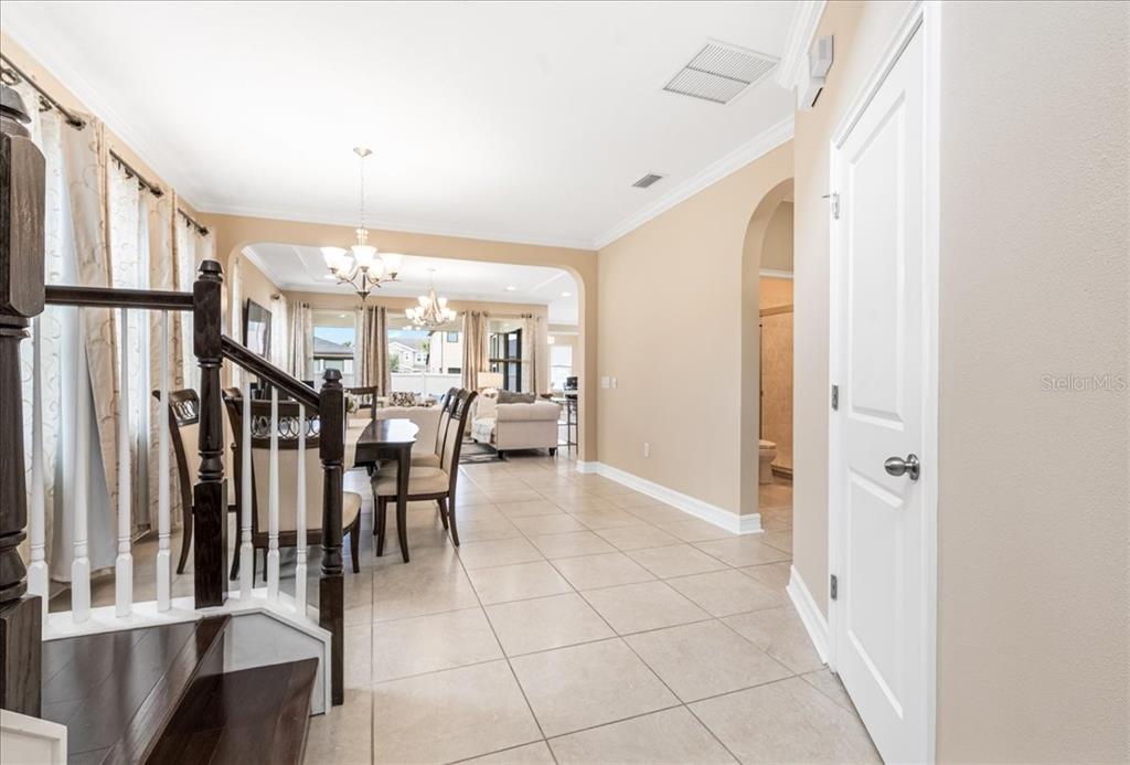 A view from the stairs looking into a dining area and living room with tile — 3963 EMPOLI COURT, WESLEY CHAPEL, FL
