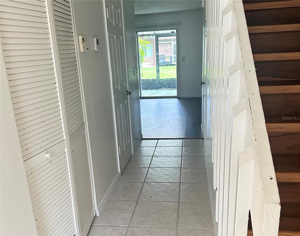 A tiled hallway leads to a sliding glass door with stairs on the right — 5123 PICADILLY CIRCUS COURT UNIT 2, ORLANDO, FL