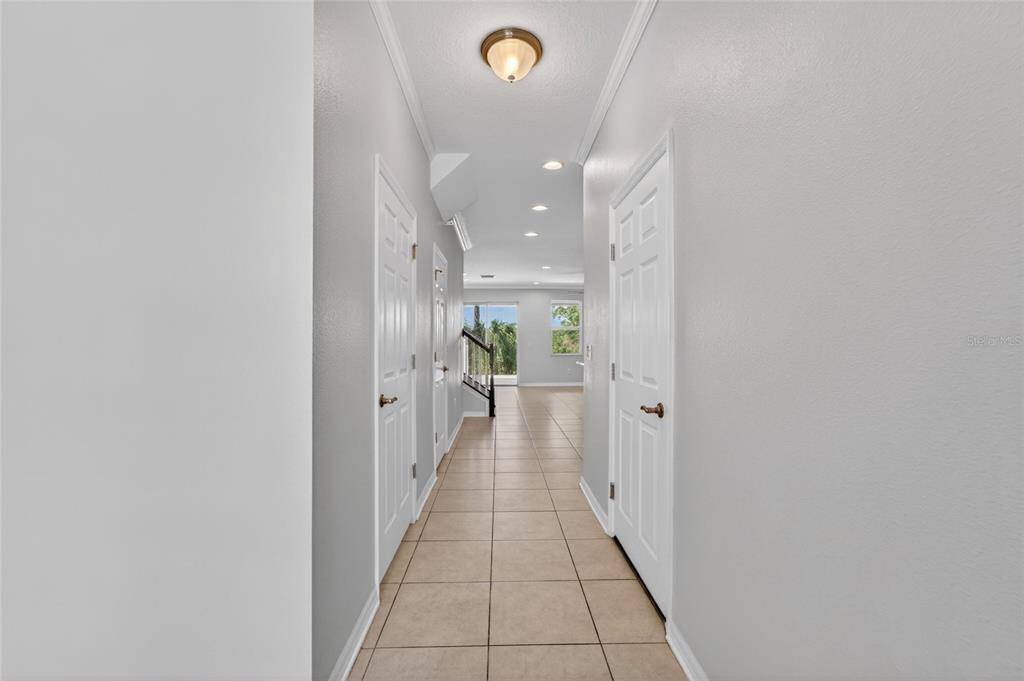 A hallway with tiled floors leads to an open living area with a staircase — 8108 MUDDY PINES PLACE, TAMPA, FL