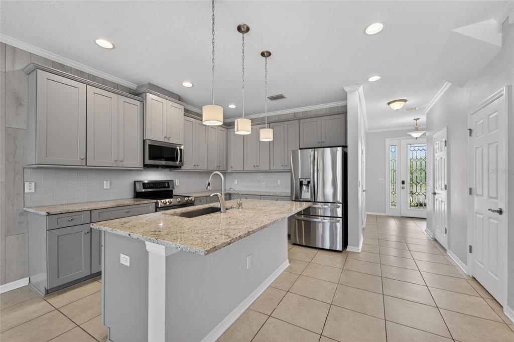A kitchen with gray cabinets, granite countertops, a center island, and stainless steel appliances — 8108 MUDDY PINES PLACE, TAMPA, FL