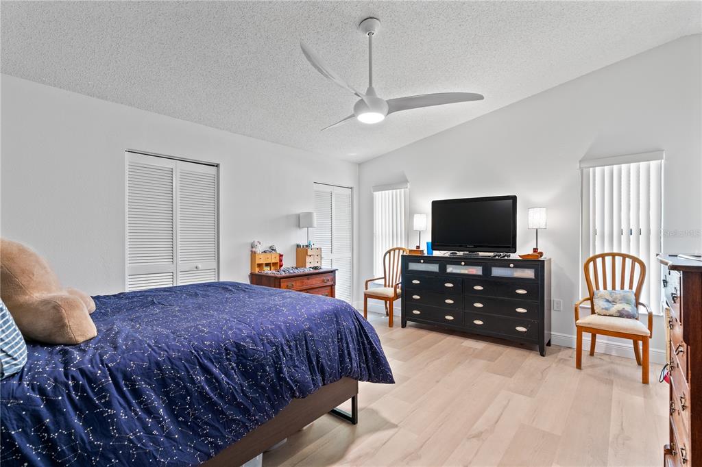 A bedroom features a bed with a constellation-patterned comforter, a black dresser, and a ceiling fan — 1967 LONG BOAT DRIVE, LAKELAND, FL