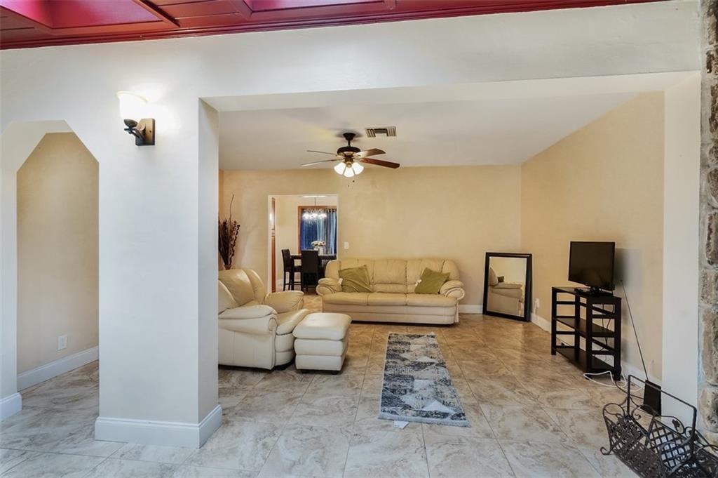 A living room with tile floors, a ceiling fan, and a beige leather sofa set — 617 Lakeside Harbour, Boynton Beach FL 33435, BOYNTON BEACH, FL