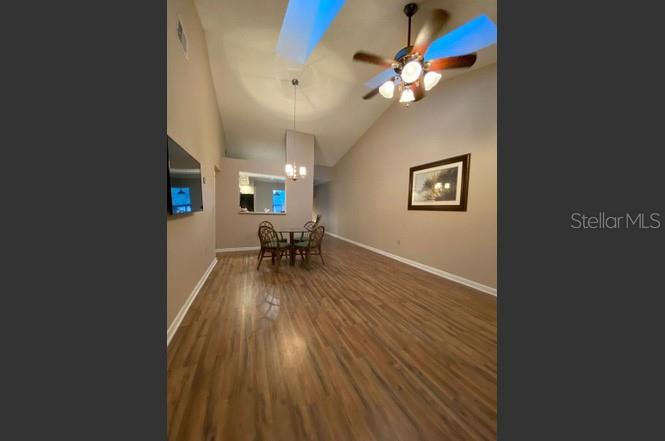 A spacious living and dining area features vaulted ceilings, wood-look flooring, and a ceiling fan — 3118 S SEMORAN BOULEVARD UNIT N8, ORLANDO, FL