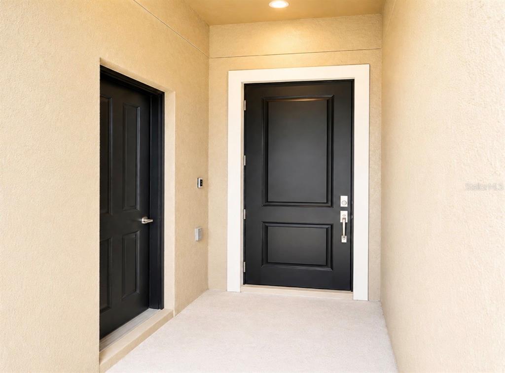 A recessed entryway features a black front door and a smaller adjacent black door — 8979 CHIPPING SQUARE LANE, DAVENPORT, FL