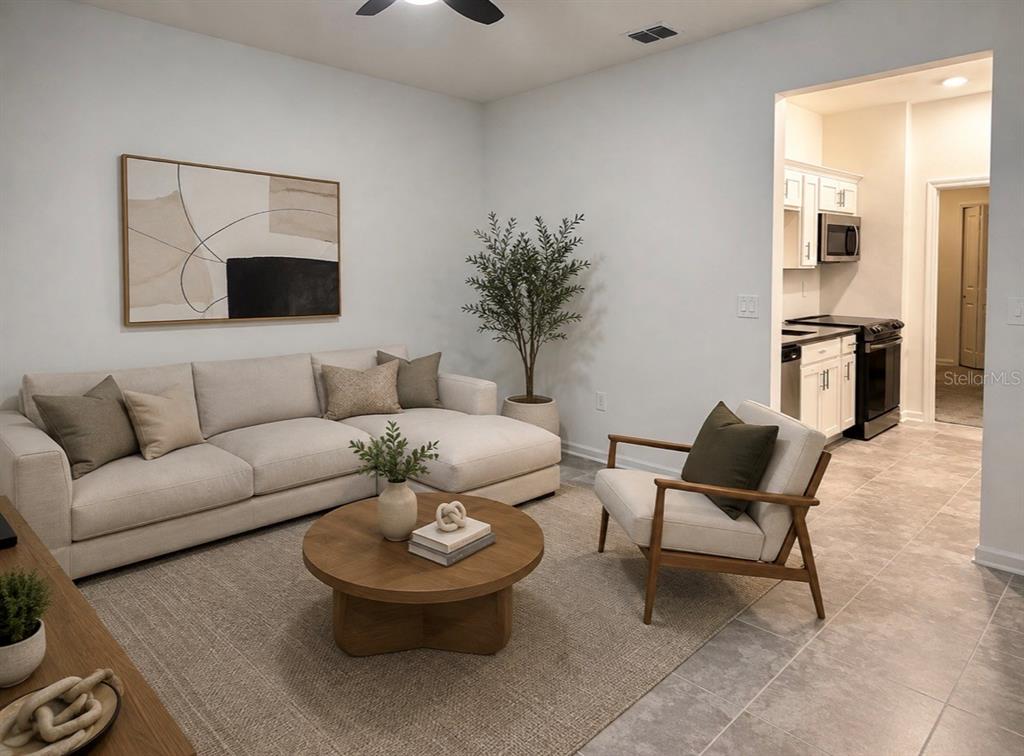 A living room features a beige sectional sofa, a round wooden coffee table, and an armchair — 8979 CHIPPING SQUARE LANE, DAVENPORT, FL