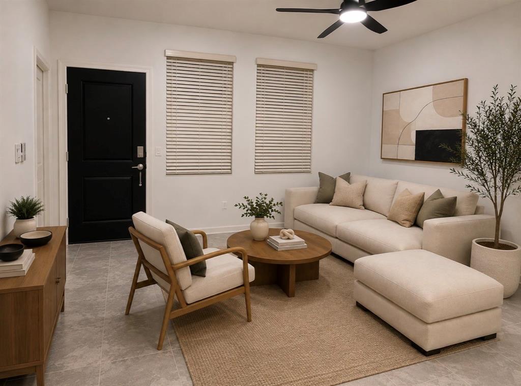 A living room features a beige sofa, a wooden coffee table, and a black door — 8979 CHIPPING SQUARE LANE, DAVENPORT, FL