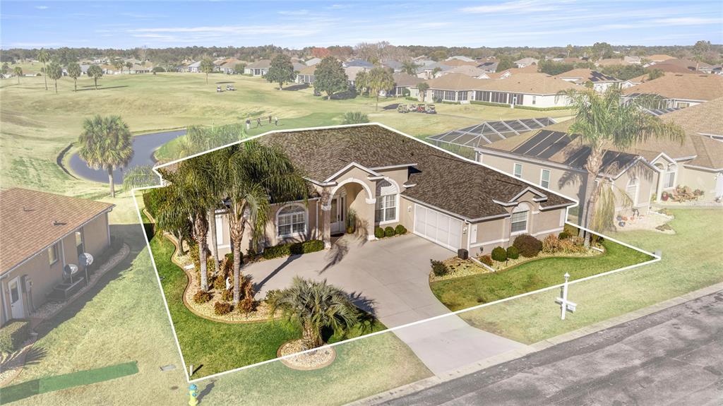 An aerial view shows a single-story house with a concrete driveway and palm trees — 5801 NW 18TH STREET, OCALA, FL