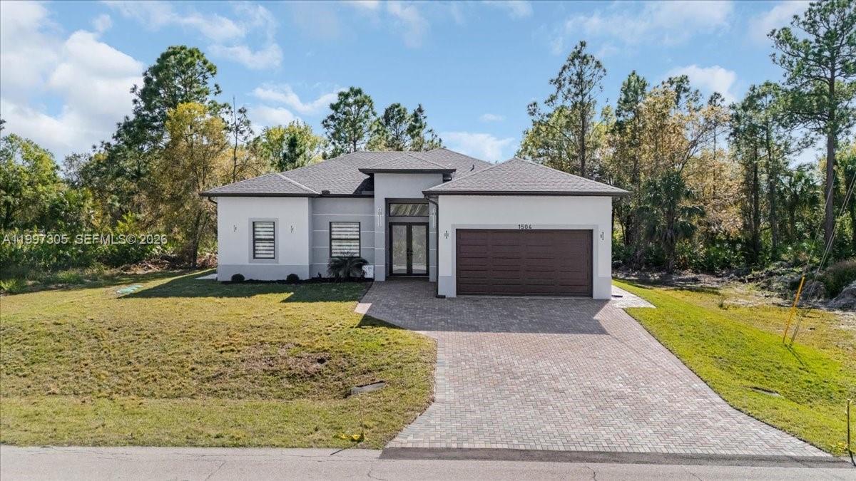 A single-story house with a brown garage door, gray exterior, and a paved driveway — 1504 E 6th, Lehigh Acres FL 33972, LEHIGH ACRES, FL