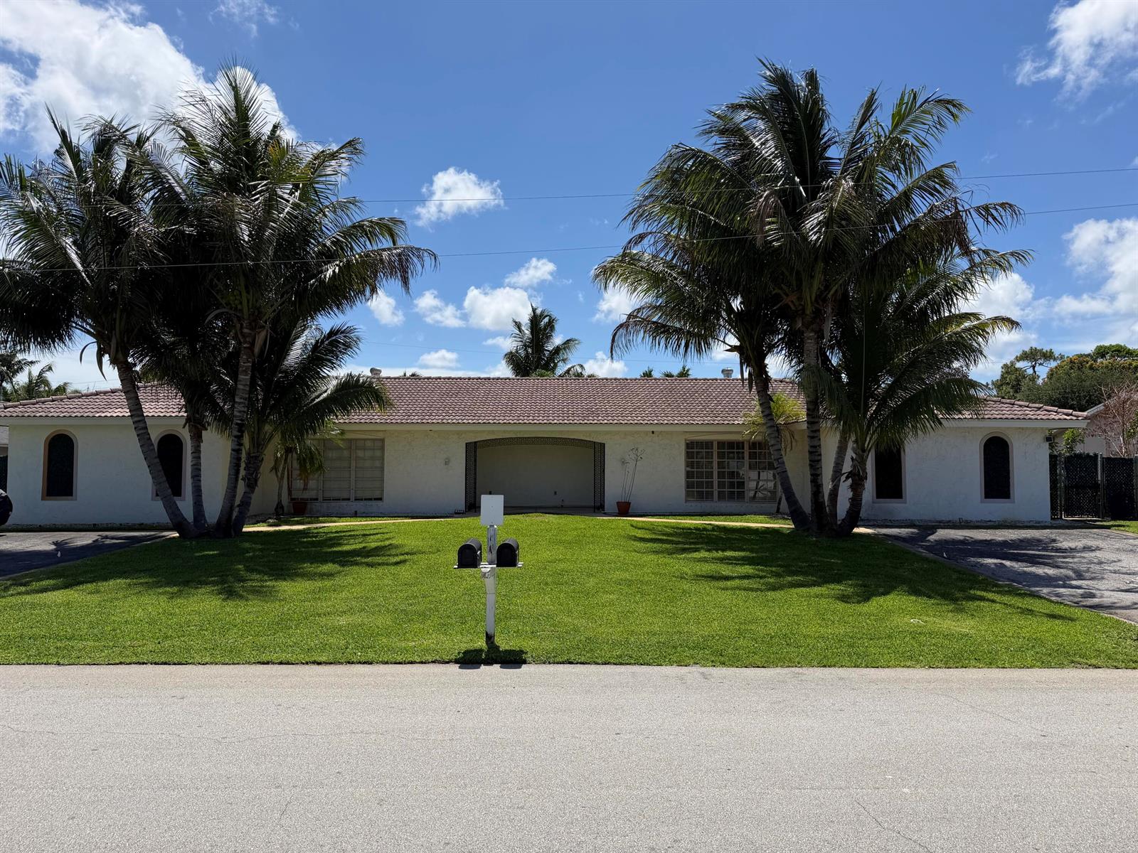 A single-story white house with a tiled roof and two large palm trees in front — 499 W Conference Drive, Boca Raton FL 33486, BOCA RATON, FL