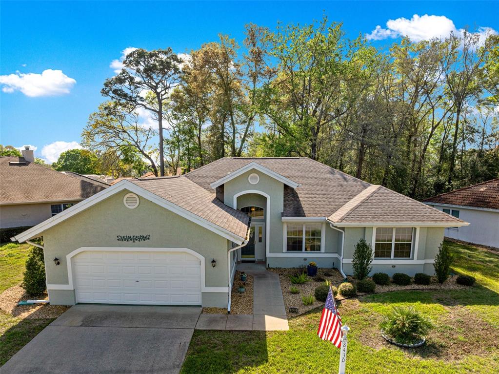 A view from a blue front door into a living area with wood-look flooring — 8430 SW 108TH PLACE ROAD, OCALA, FL