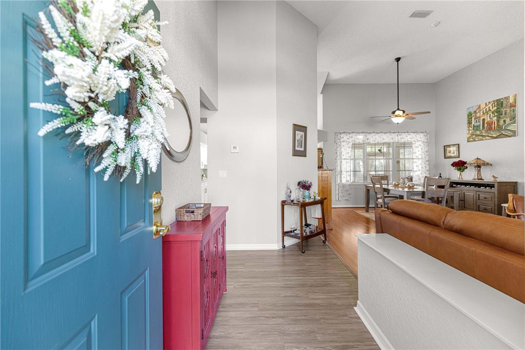 A living room features brown leather sofas, a white coffee table, and wood-look flooring — 8430 SW 108TH PLACE ROAD, OCALA, FL