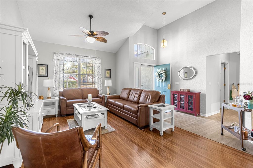 A dining room with wood floors, a table for four, and high vaulted ceilings — 8430 SW 108TH PLACE ROAD, OCALA, FL