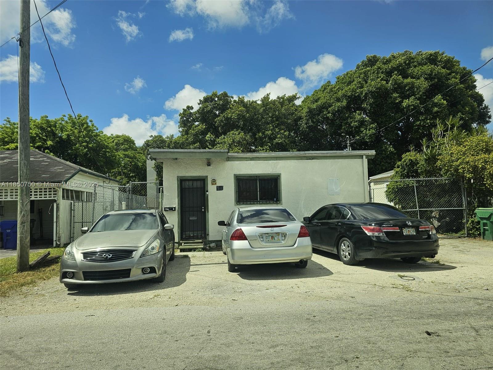 A single-story house with a flat roof and three parked cars in the front yard — 140 NE 83rd St, Miami FL 33138, MIAMI, FL