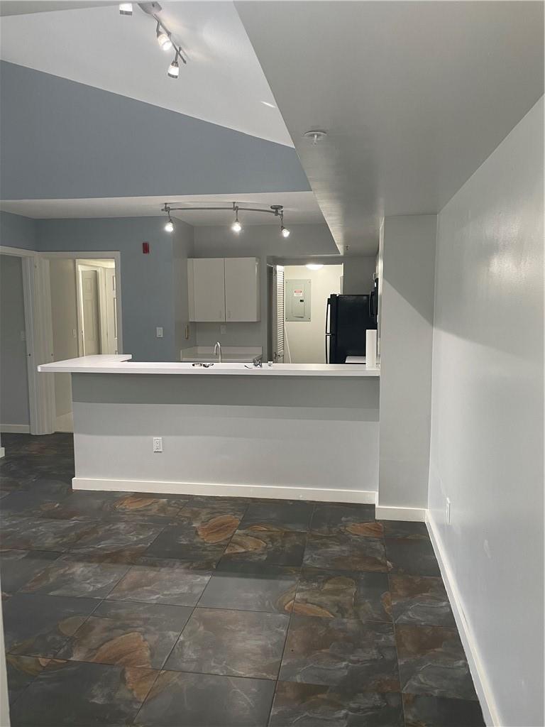 A kitchen with a breakfast bar, slate-style tile flooring, and track lighting — 2640 S University Drive # 319, Davie FL 33328, DAVIE, FL