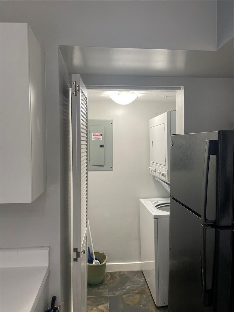 A laundry closet with a stacked washer and dryer and an electrical panel on the wall — 2640 S University Drive # 319, Davie FL 33328, DAVIE, FL