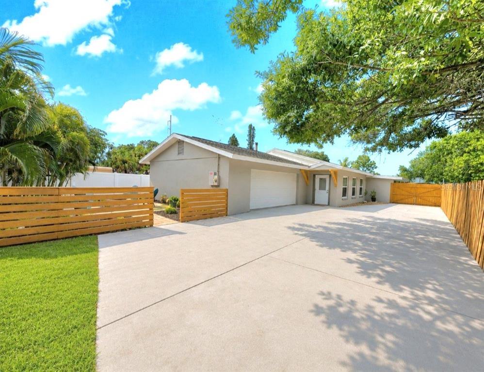 A single-story house with a white garage door, a side entrance, and a wooden fence — 138 DAVISON AVENUE NE, ST PETERSBURG, FL