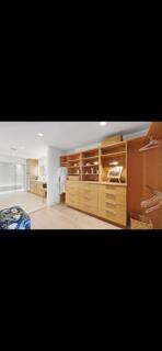 A walk-in closet features light wood cabinetry, open shelving, and a view into a bathroom — 6110 N Ocean Boulevard # 39, Ocean Ridge FL 33435, OCEAN RIDGE, FL