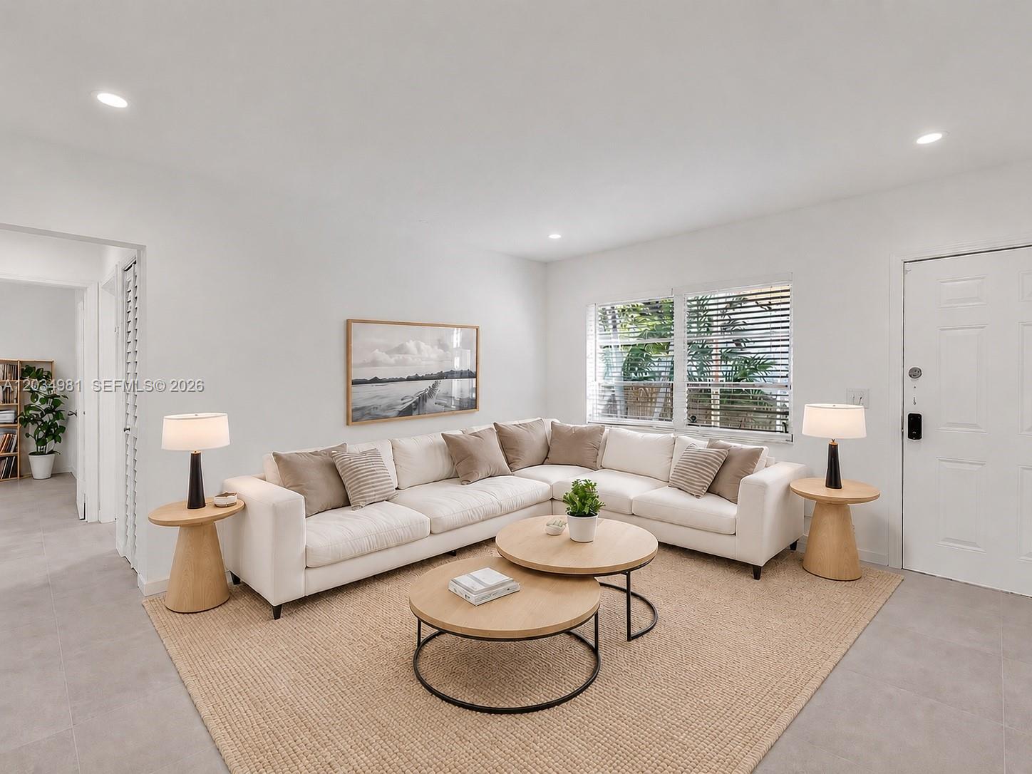 A living room features a white sectional sofa, two round coffee tables, and side tables — 545 NE 64th St, Miami FL 33138, MIAMI, FL