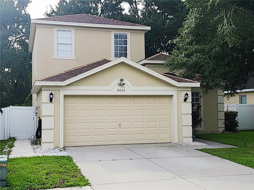 A two-story house with a beige stucco exterior and a two-car garage — 8604 TIDAL BREEZE DRIVE, RIVERVIEW, FL