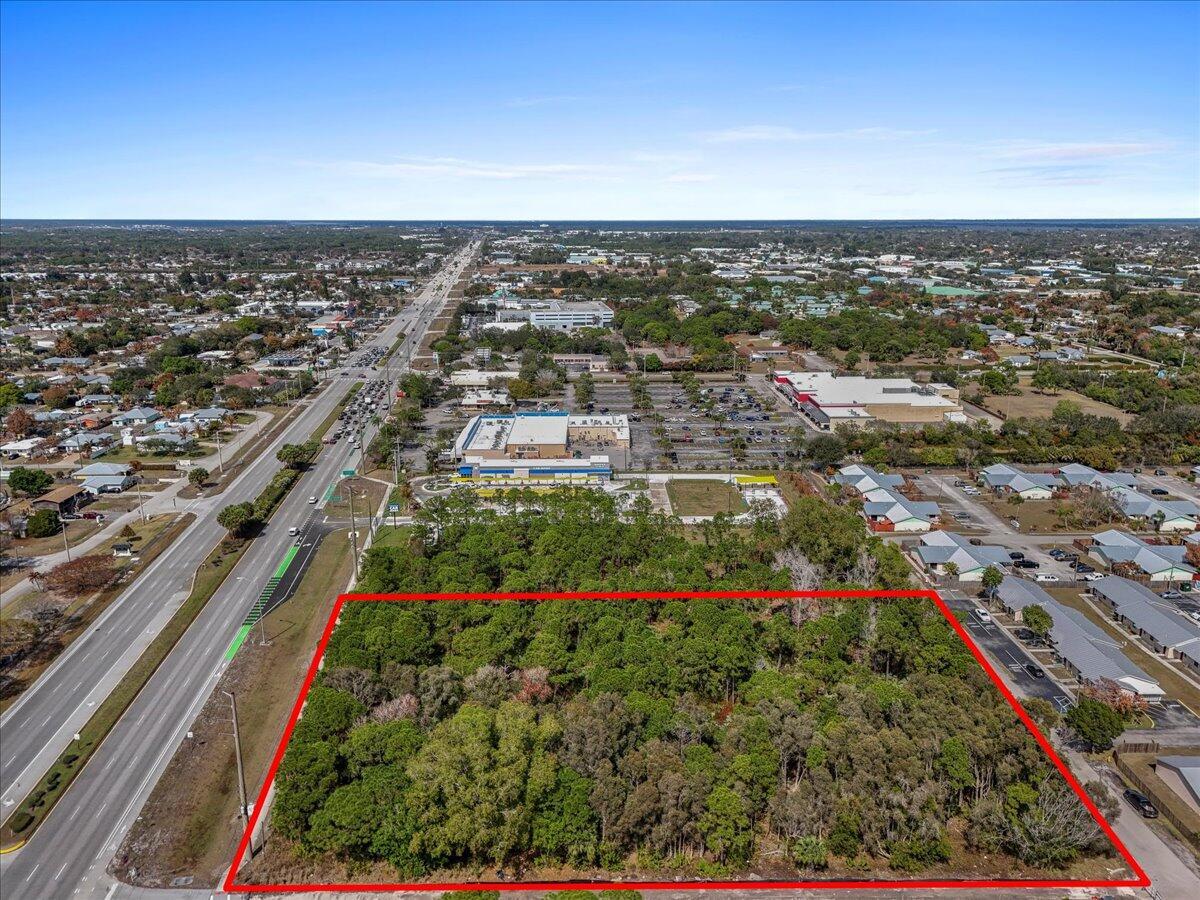 An aerial view shows a rectangular, tree-covered vacant lot outlined in red next to a highway — 0 SE Federal Highway, Stuart FL 34994, STUART, FL