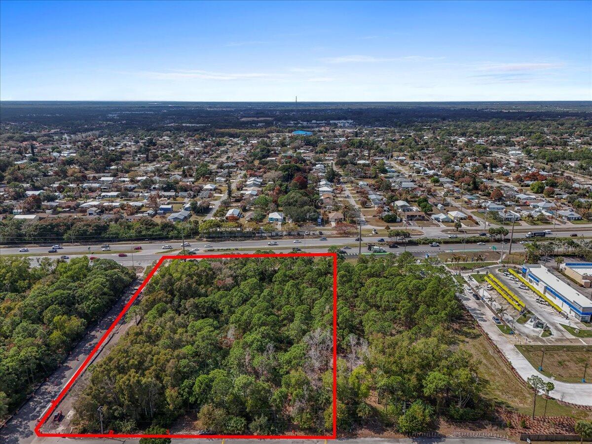 An aerial view shows a rectangular, wooded vacant lot outlined in red next to a road — 0 SE Federal Highway, Stuart FL 34994, STUART, FL