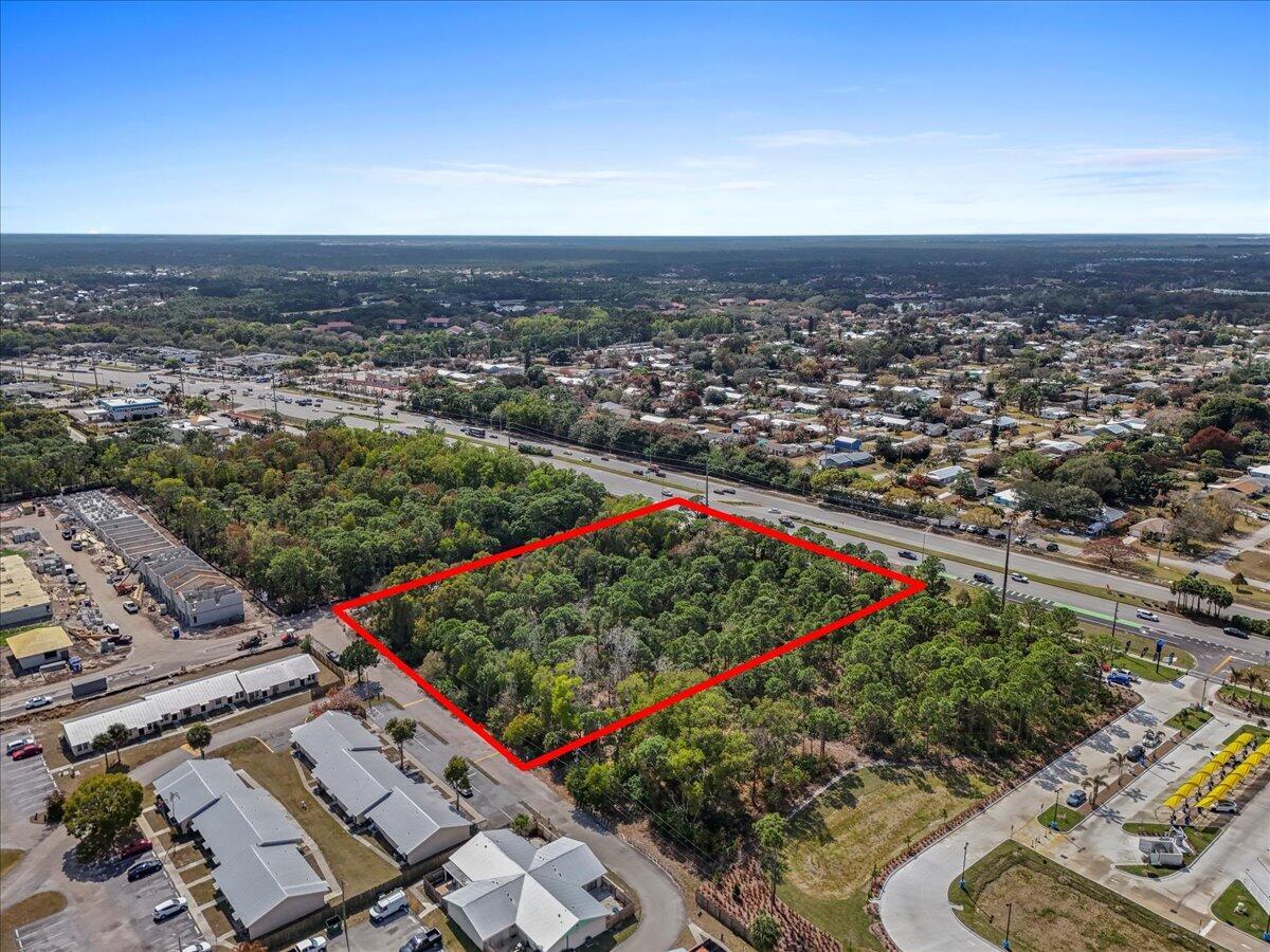 An aerial view shows a rectangular, wooded vacant lot outlined in red near a highway — 0 SE Federal Highway, Stuart FL 34994, STUART, FL