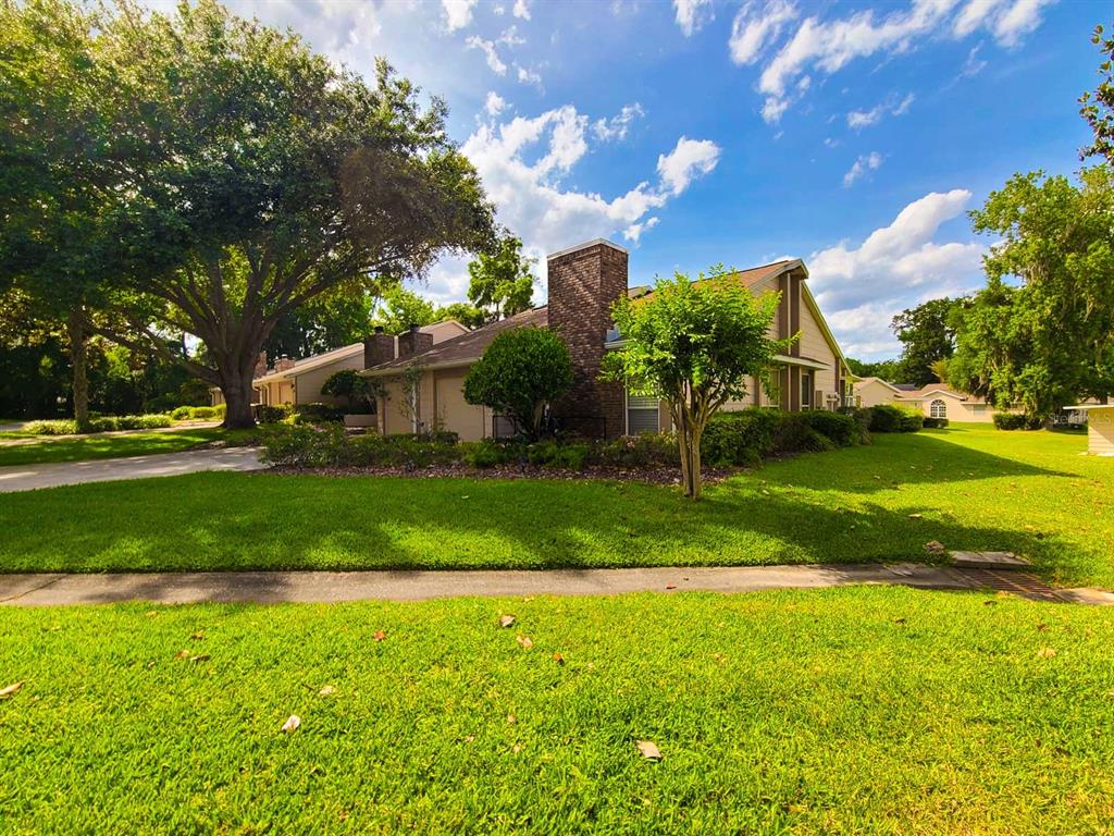 A single-story house with a brick chimney and a large tree in the front yard — 2321 SE 19TH CIRCLE, OCALA, FL
