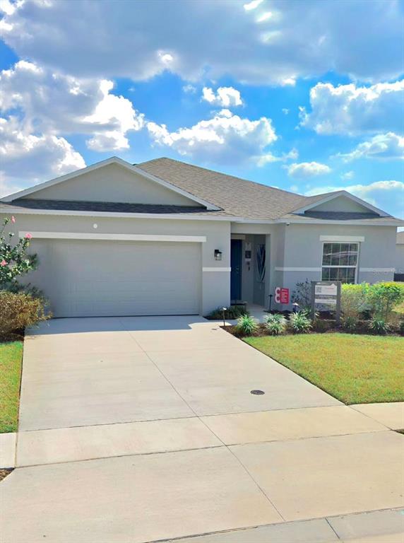 A single-story house features a light gray exterior, a two-car garage, and a concrete driveway — 3921 SOUTHERN VISTA LOOP, ST CLOUD, FL