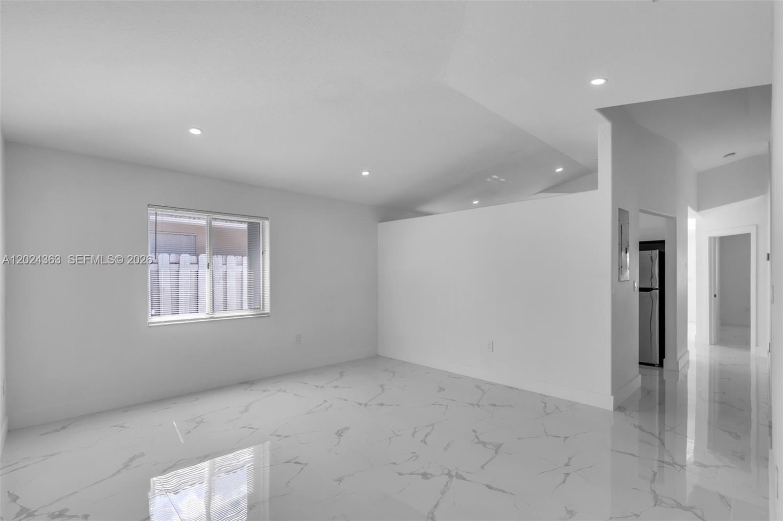 A bright, minimalist room features white walls, recessed lighting, and polished white marble-look tile flooring — 9703 NW 127th St, Hialeah Gardens FL 33018, HIALEAH GARDENS, FL