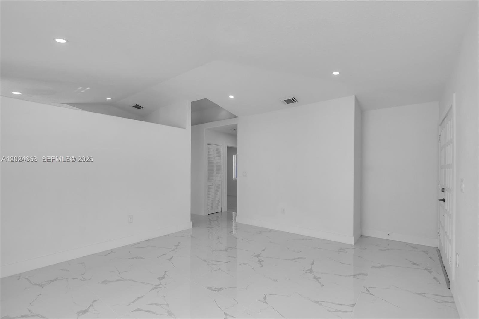 A bright, empty room features white walls, recessed lighting, and polished marble-look tile flooring — 9703 NW 127th St, Hialeah Gardens FL 33018, HIALEAH GARDENS, FL