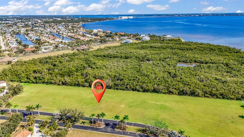 An aerial view shows a large, vacant grassy lot with a red location pin — 4661 GRASSY POINT BOULEVARD, PORT CHARLOTTE, FL