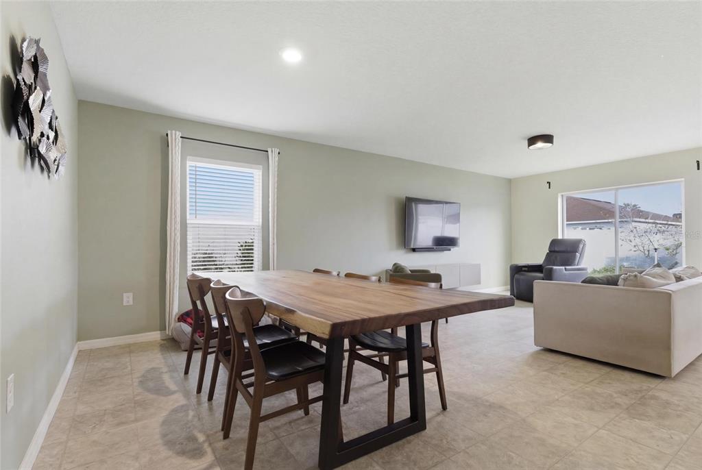 A bedroom features a wooden bed frame, a dresser, a ceiling fan, and a window — 10624 MASSIMO DRIVE, WIMAUMA, FL