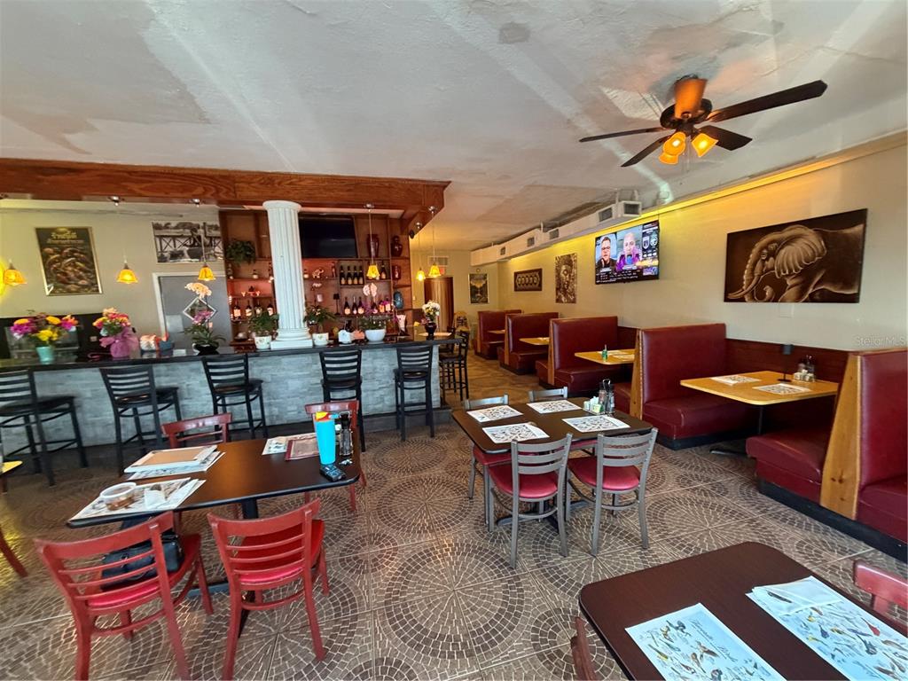 A restaurant interior features a bar, booth seating, tables with chairs, and tiled flooring — 1840 DREW STREET, CLEARWATER, FL