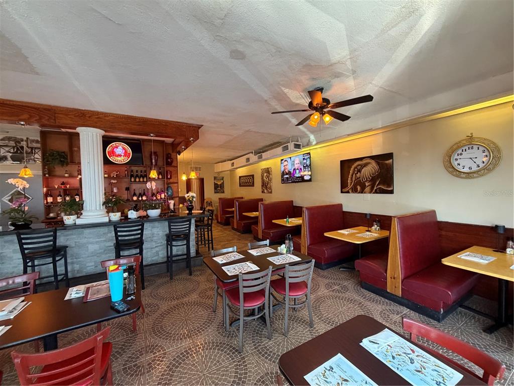A restaurant interior features a bar, red booth seating, tables, and tiled flooring — 1840 DREW STREET, CLEARWATER, FL