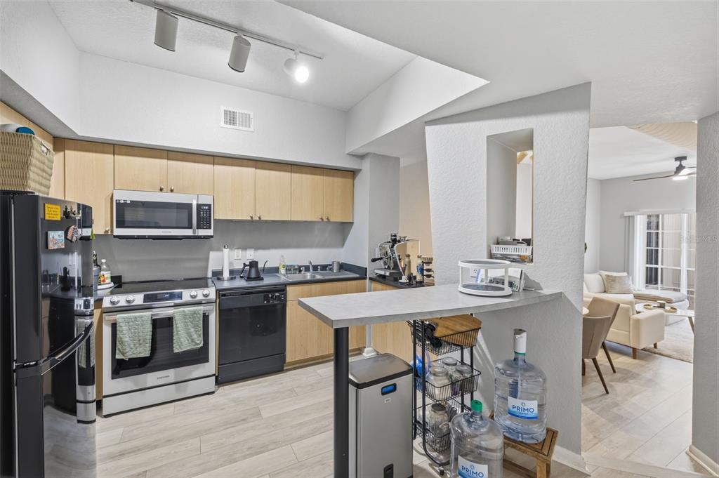 A kitchen with light wood cabinets, stainless steel appliances, and a breakfast bar — 520 S ARMENIA AVENUE UNIT 1239A, TAMPA, FL