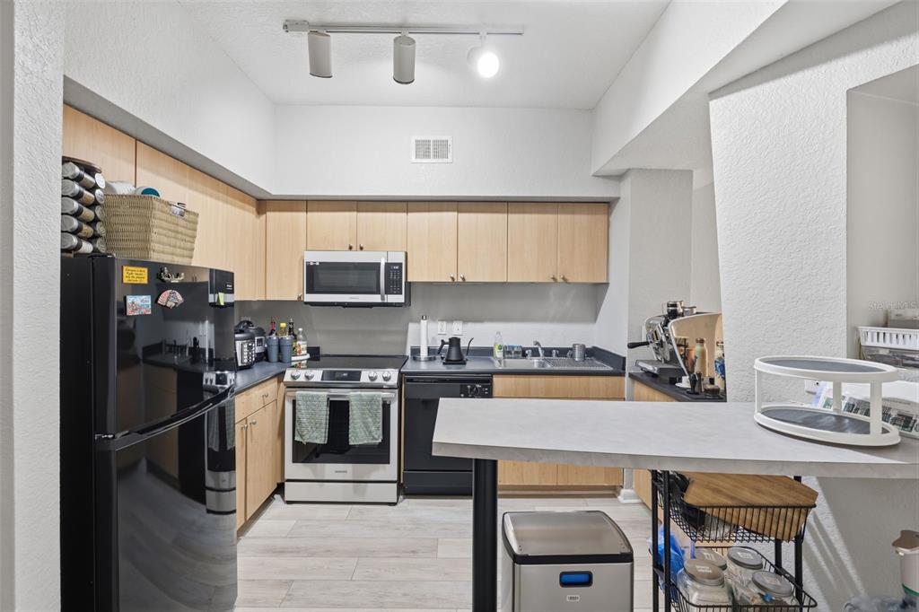 A kitchen with light wood cabinets, black appliances, and a breakfast bar — 520 S ARMENIA AVENUE UNIT 1239A, TAMPA, FL