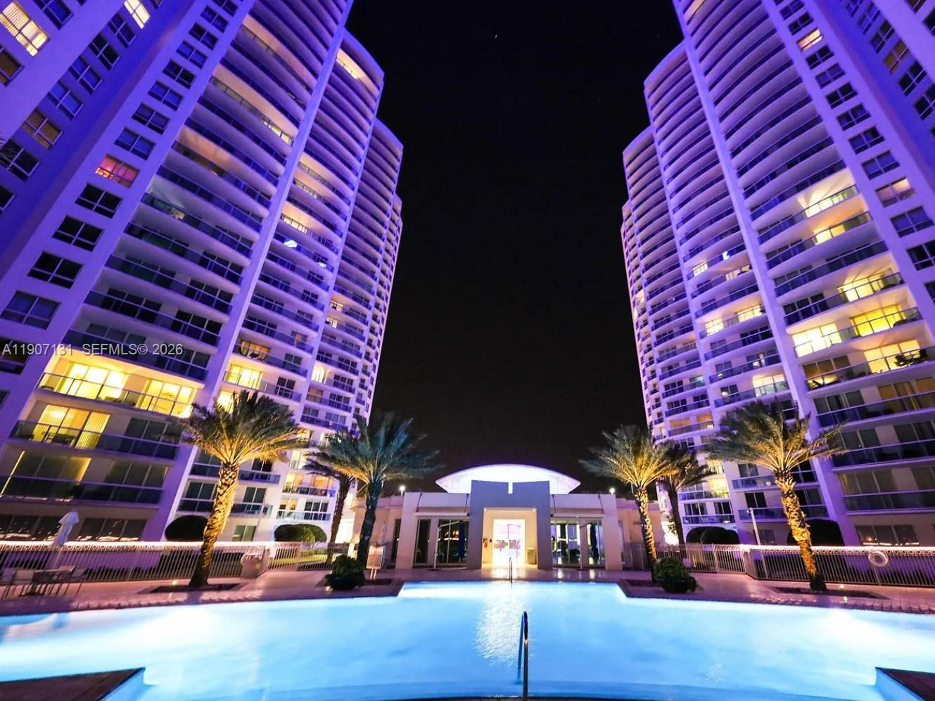 A white motorboat is docked at a pier in front of two tall residential towers — 231 Riverside Dr # 510, Daytona FL 32117, DAYTONA, FL