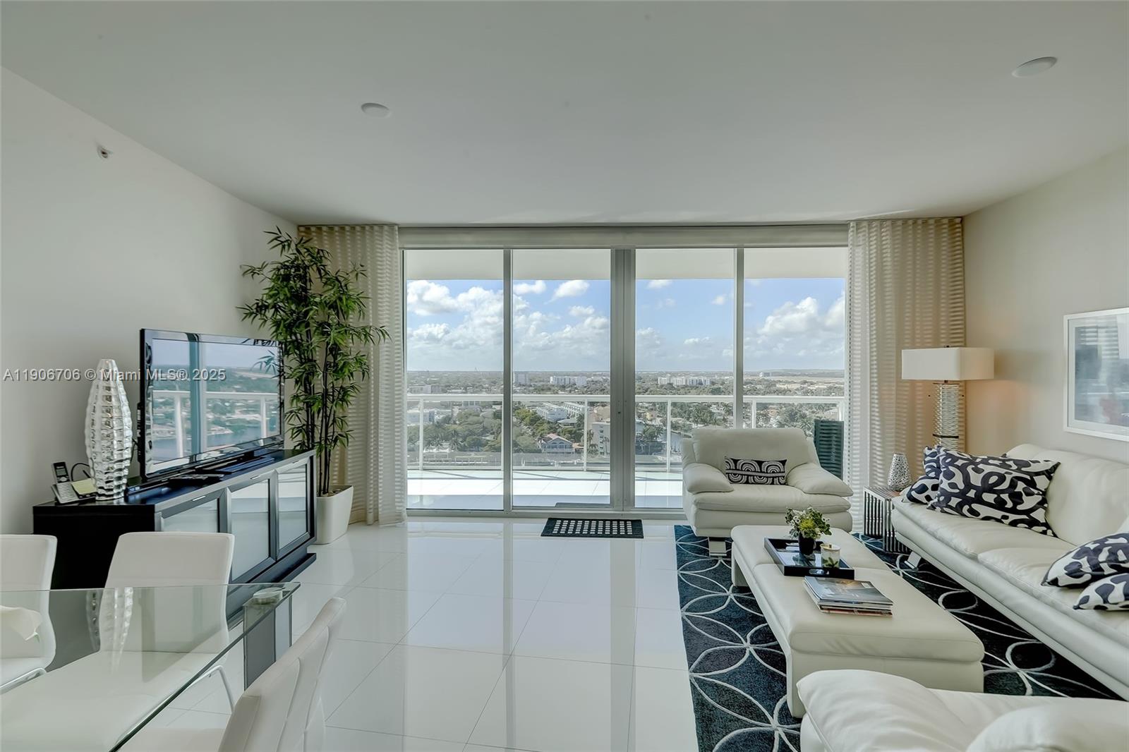 A bright living room features white tile floors, a large balcony, and a city view — 1 N Ocean Blvd # 1411, Pompano Beach FL 33062, POMPANO BEACH, FL