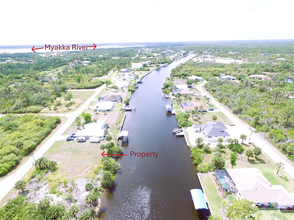 An aerial view shows a waterfront property along a canal leading to the Myakka River — 13572 WAINWRIGHT DRIVE, PORT CHARLOTTE, FL