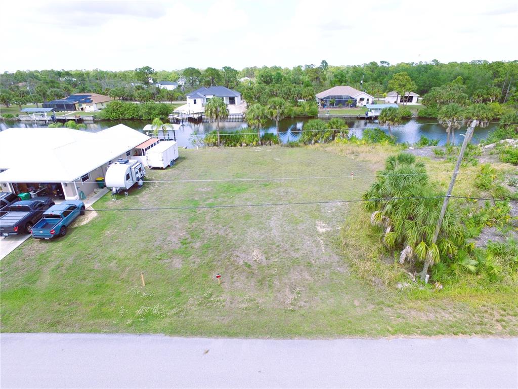 An aerial view shows a vacant grassy lot adjacent to a house with a camper — 13572 WAINWRIGHT DRIVE, PORT CHARLOTTE, FL