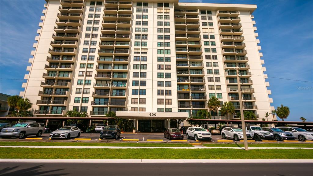 A multi-story residential building with balconies and a covered parking area in front — 400 ISLAND WAY UNIT 212, CLEARWATER BEACH, FL