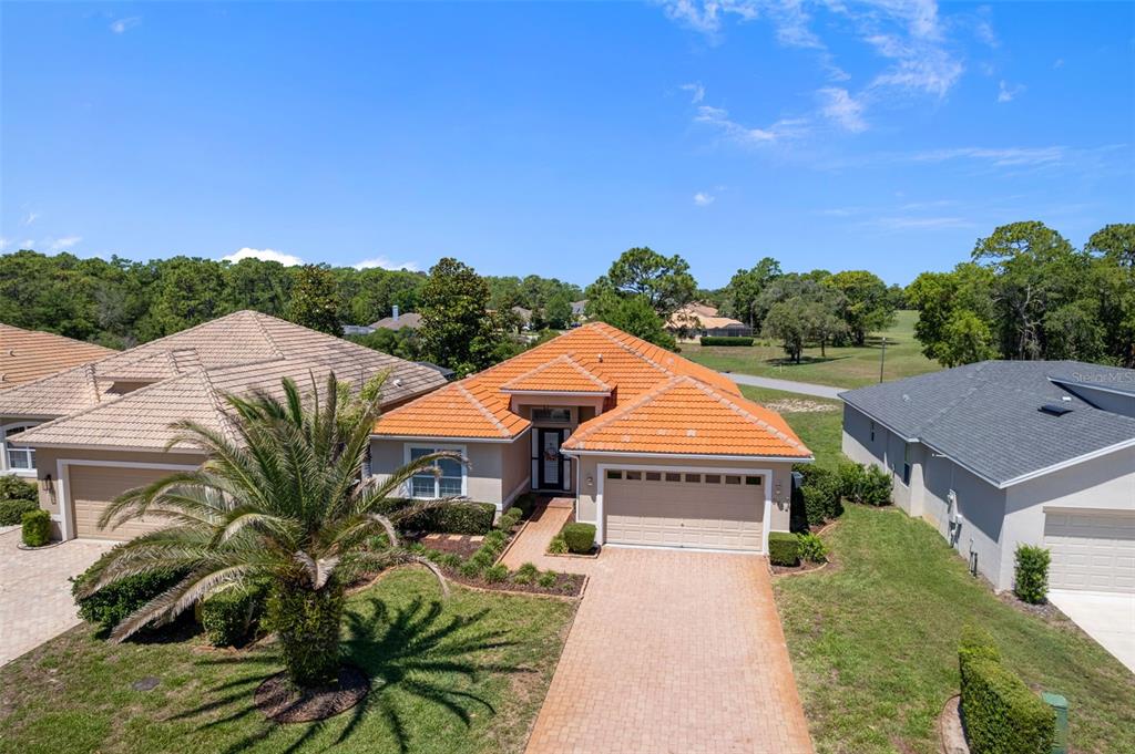 An aerial view of a single-story house with a terracotta tile roof and brick driveway — 8984 WADE STREET, WEEKI WACHEE, FL