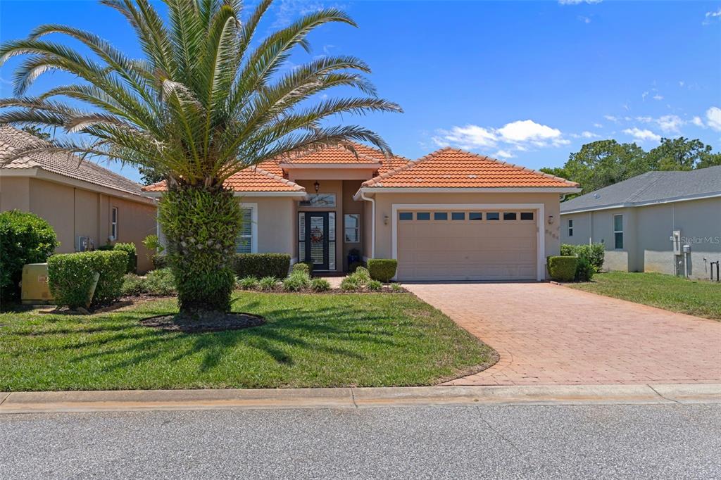 A single-story house with a terracotta tile roof, a palm tree, and a paved driveway — 8984 WADE STREET, WEEKI WACHEE, FL