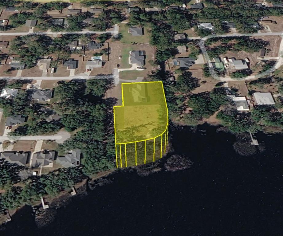 An aerial view shows a residential lot highlighted in yellow bordering a large lake — 0 MIDDLE STREET, GROVELAND, FL
