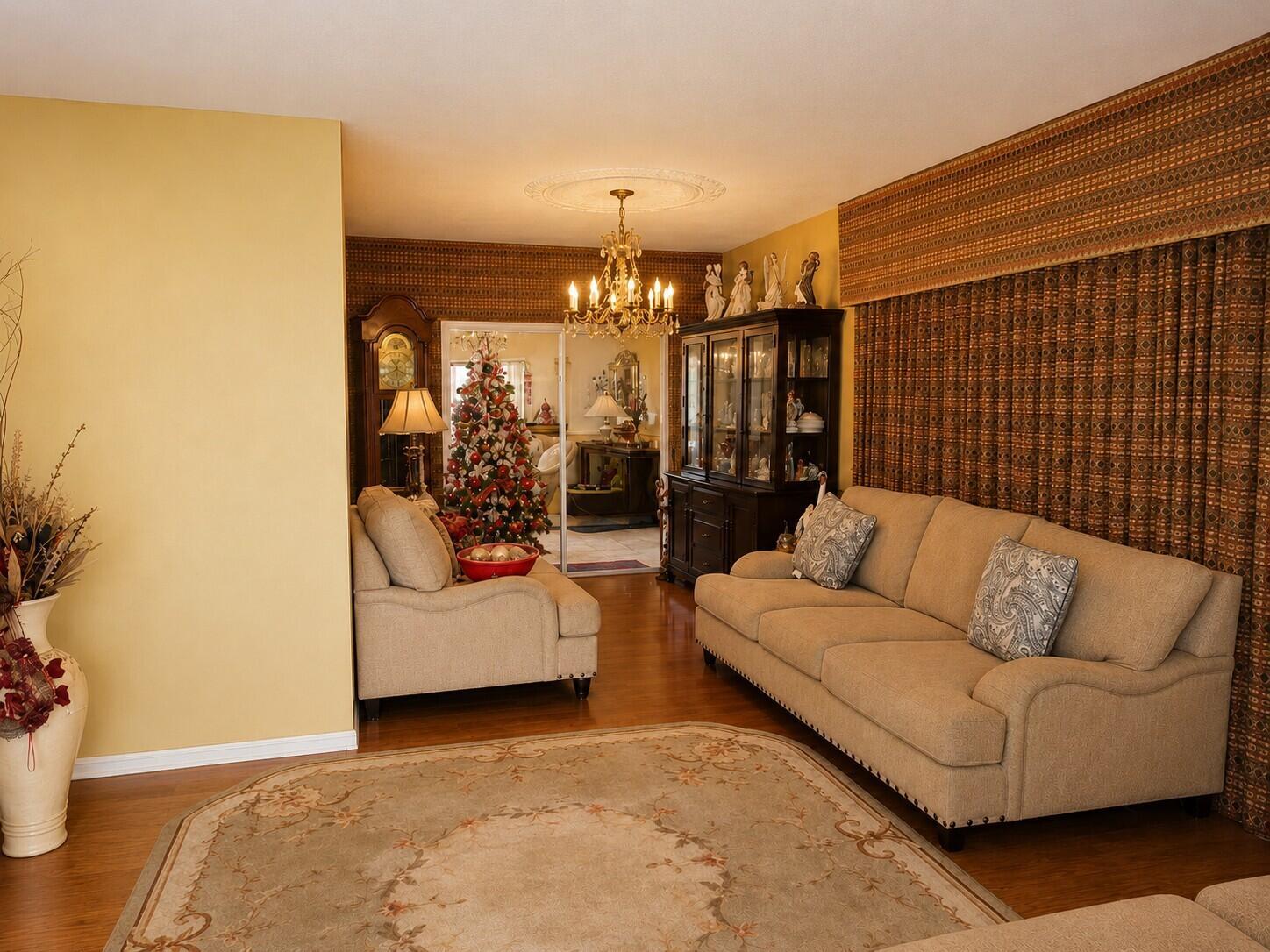 A living room features beige sofas, a patterned rug, a chandelier, and floor-to-ceiling curtains — 14620 E Polk Street, Miami FL 33176, MIAMI, FL