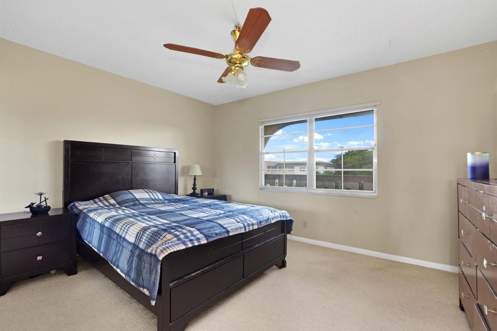 A screened-in balcony with tiled flooring, a small table, and a view of a lake — 2101 Lucaya Bend # D4, Coconut Creek FL 33066, COCONUT CREEK, FL