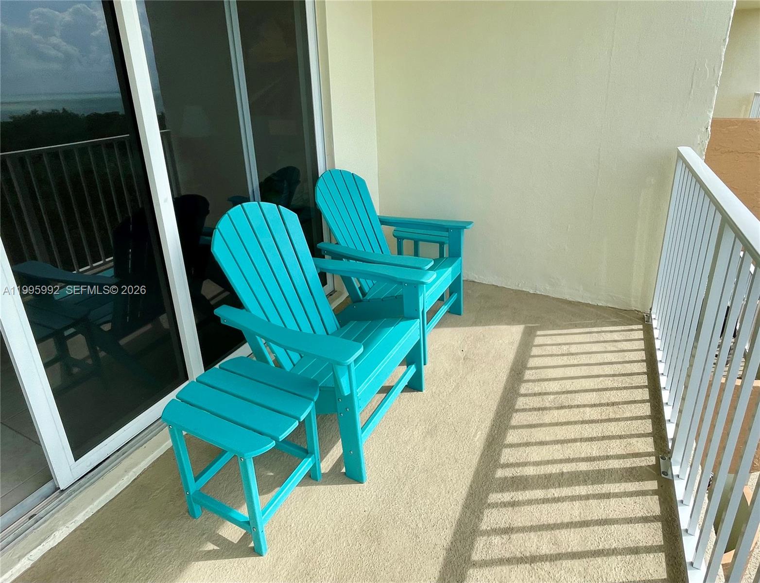 A balcony features two turquoise Adirondack chairs and a matching side table — 200 Wrenn # 502, Plantation Key FL 33070, PLANTATION KEY, FL