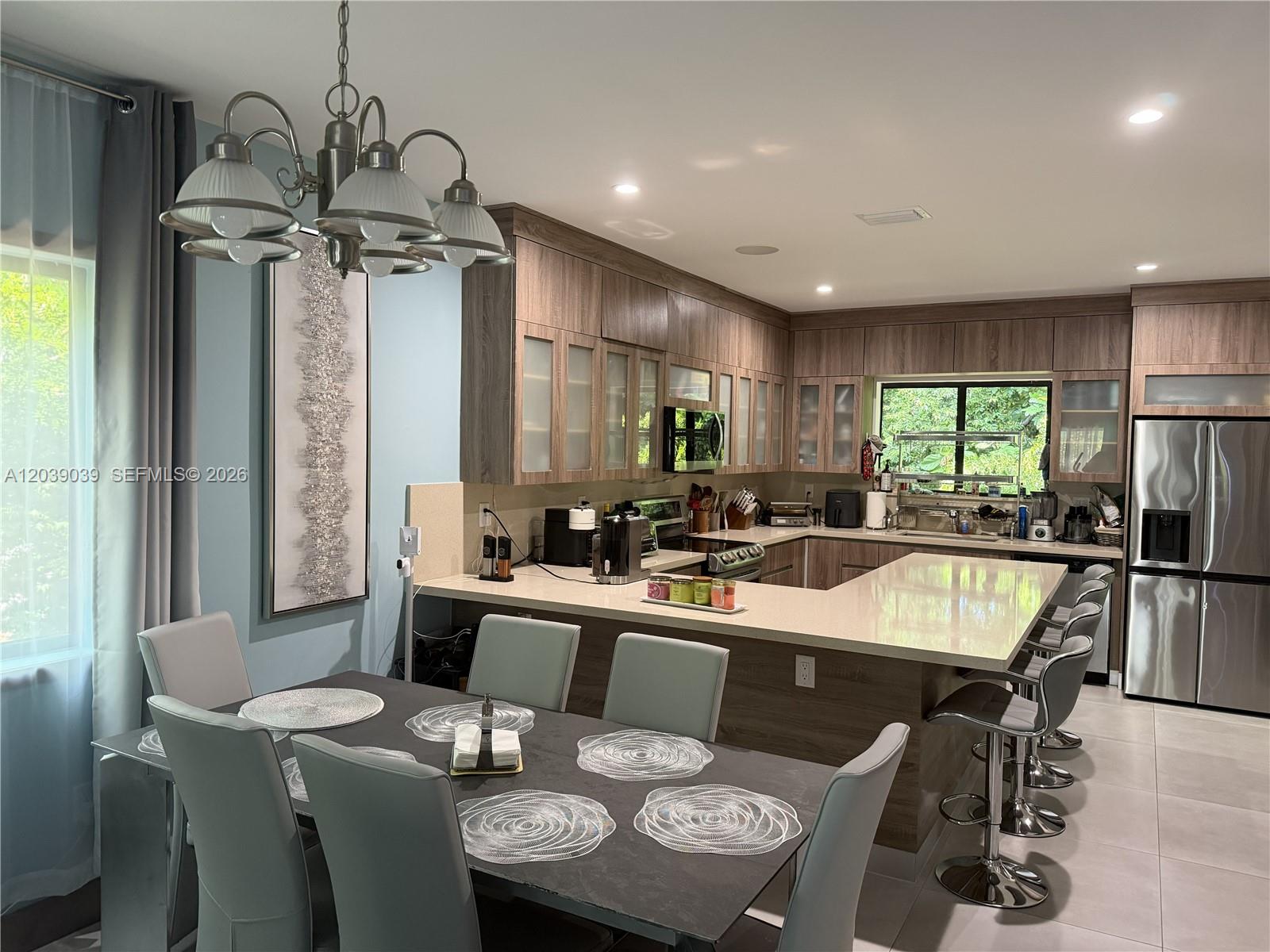 A kitchen with wood-toned cabinets and a dining area featuring a six-chair table — KEY LARGO, FL