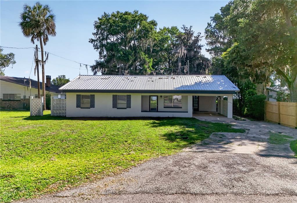 A single-story house with a metal roof, a carport, and a large front lawn — 4136 CR 400, LAKE PANASOFFKEE, FL